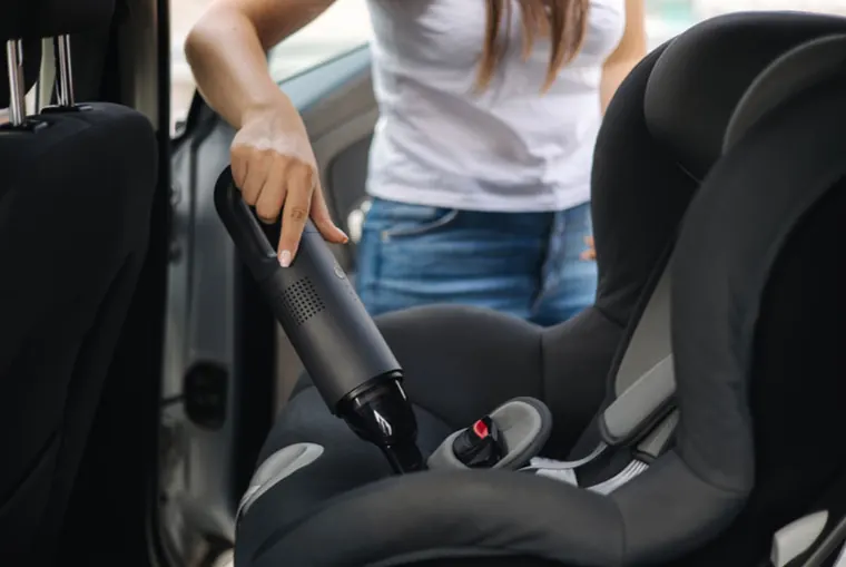 Vacuuming crumbs out of a car seat